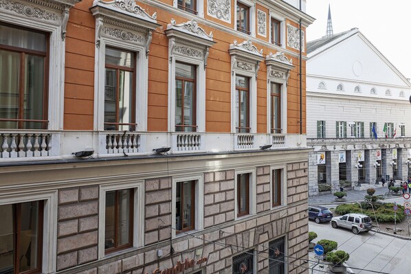 A multi-story building with ornate architectural details, including decorative moldings and a balcony with balustrades.