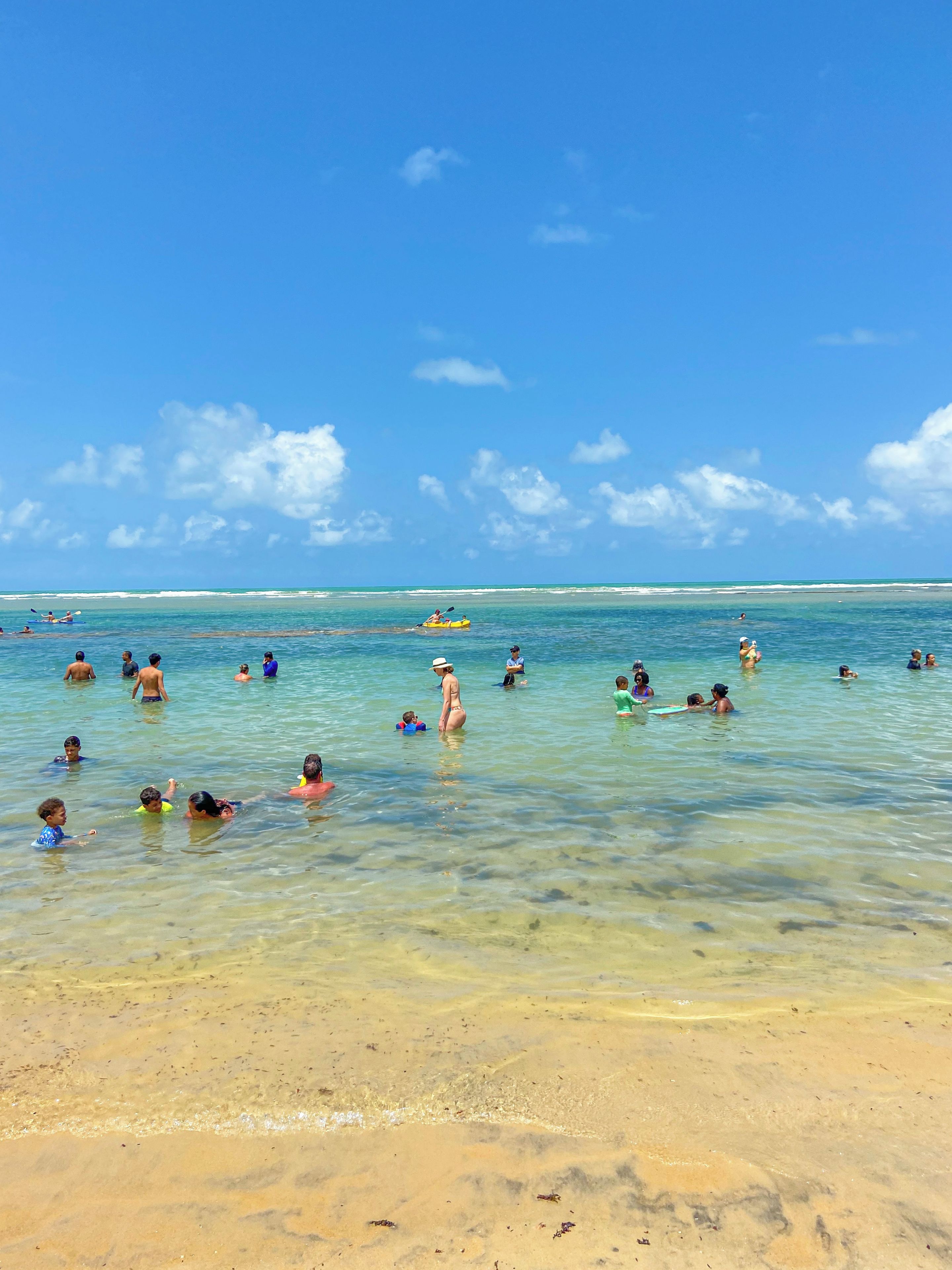 Eine Strandansicht mit klarem, blauem Wasser und einem sandigen Ufer.