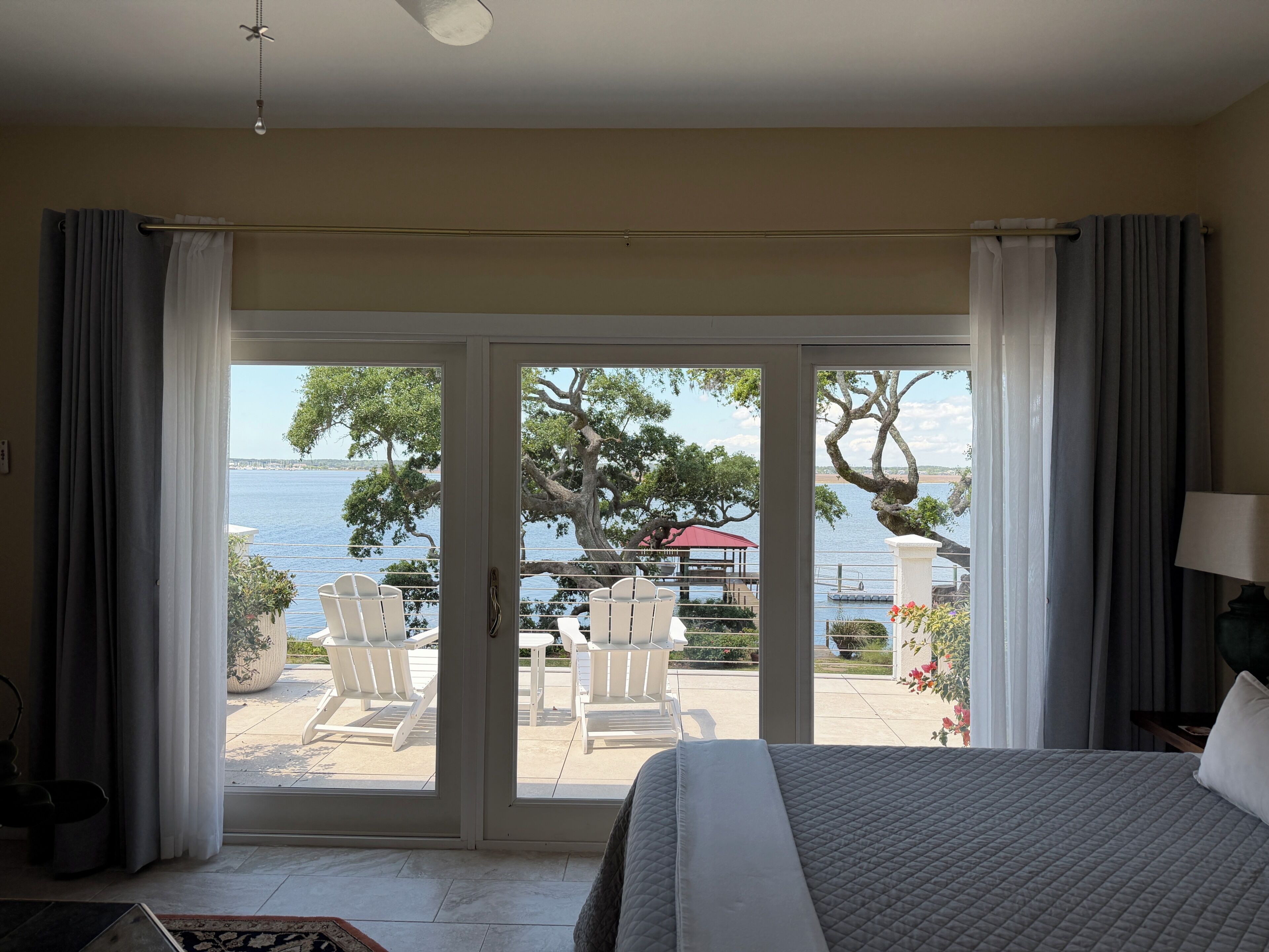 Ein Hotelzimmer mit Bett, Meerblick und einer Terrasse mit Stühlen und Tisch.