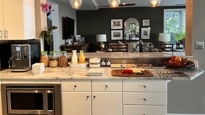 A modern kitchen with a central island, built-in appliances, and pendant lighting.