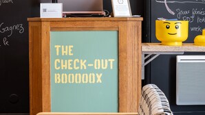 A check-out counter with a sign reading "THE CHECK-OUT BOOOOXX" and a laptop on top. - greet Chartres Est (Chartres)