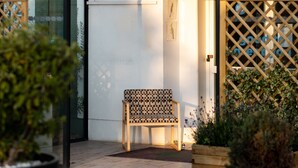 The exterior of the Greet Hotel with a signboard, a wooden bench, and potted plants. - greet Chartres Est (Chartres)