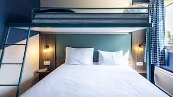 A bunk bed room with a ladder, two bedside tables with lamps, and a window with curtains.