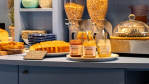 A buffet with various food items including cakes, pastries, and jars of honey. - greet Chartres Est (Chartres)