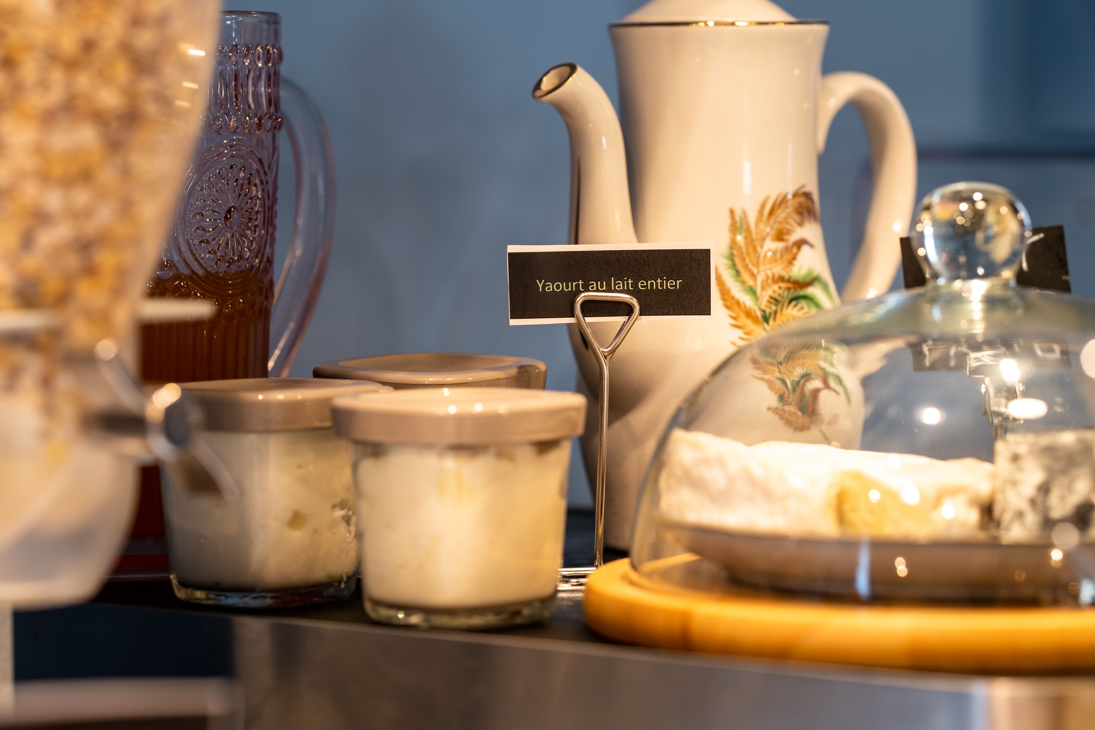 A selection of dairy products including a pitcher, jars, and a glass container with a lid, likely used for serving or storing dairy items.