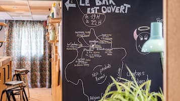 A restaurant interior with a chalkboard menu listing food items and hours of operation.