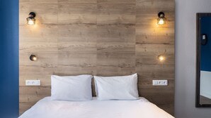 A bed with white bedding, a wooden headboard, two wall-mounted lights, and a mirror on the right. - greet Chartres Est (Chartres)