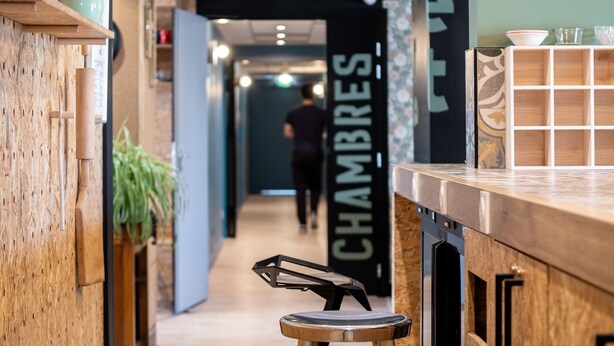 A narrow hallway with wooden walls and a bar area with stools. - greet Chartres Est (Chartres)