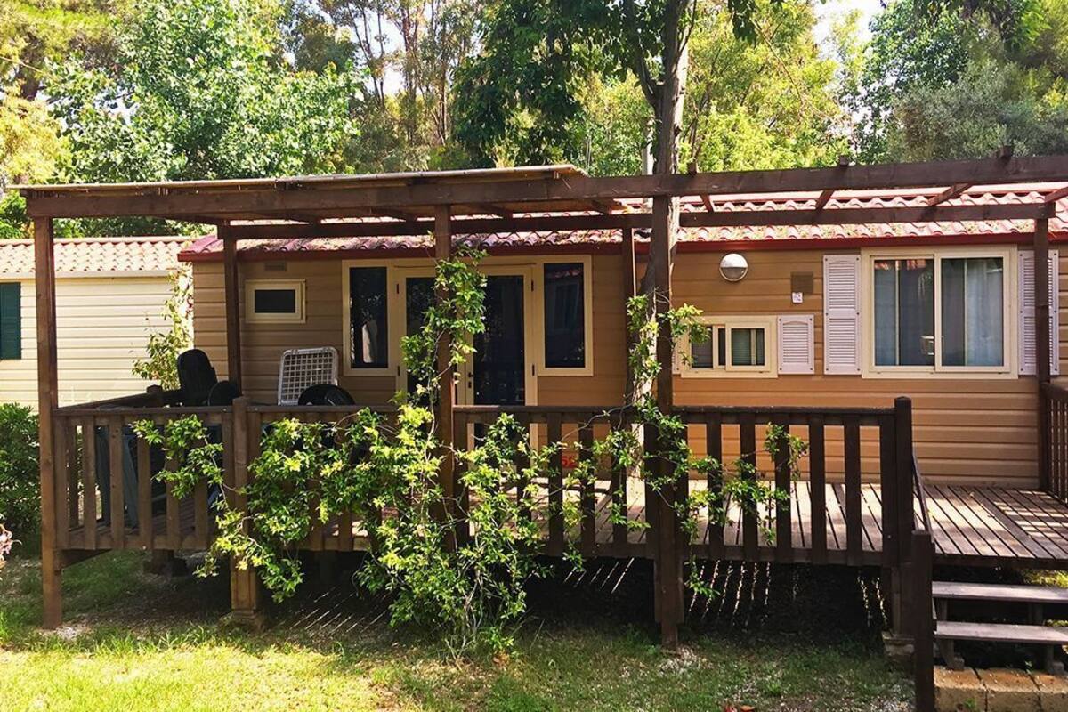 Une cabane en bois dotée d’une terrasse, d’un porche couvert et d’un petit espace barbecue extérieur.