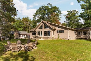 A two-story house with a large front porch and a grassy yard. - Sunset View | Superior West Twin Lake Home (Lewiston)