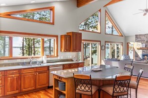 A spacious kitchen with wooden cabinets, a large island, and a dining area with chairs.