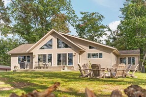 A two-story house with a large front porch, multiple windows, and outdoor seating. - Sunset View | Superior West Twin Lake Home (Lewiston)