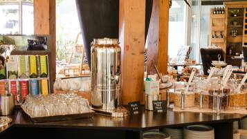 A bar area with a coffee machine, milk dispensers, and a variety of beverage containers.