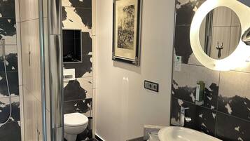 Ein modernes Badezimmer mit Dusche, Toilette und Waschbecken.