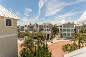 A residential area with multiple houses, a paved driveway, and palm trees.
