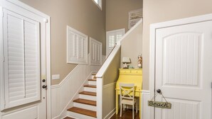 Un escalier avec des rampes blanches et un bureau jaune en arrière-plan.