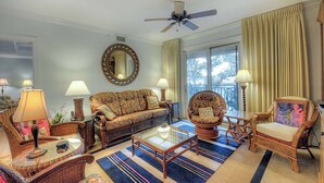 A living room with a sofa, chairs, a coffee table, and a ceiling fan. - 760 Ocean Boulevard #404 by Hodnett Cooper (St. Simons Island)