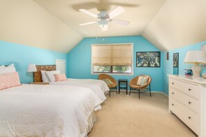 A bedroom with two beds, a ceiling fan, a window with a view, and a dresser. - 4316 7th Street by Hodnett Cooper (St. Simons Island)