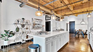 A modern kitchen with a central island, white cabinetry, and pendant lighting. - Urban Oasis In Downtown Waco; short walk to Silos (Waco)