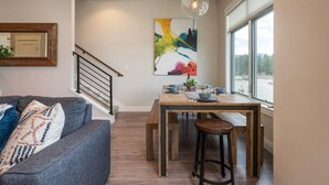 A dining area with a wooden table, bar stools, and a colorful abstract painting on the wall. - Hideaway Station TS 23 - Downtown Winter Park (Winter Park)