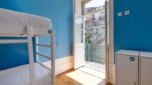 A room with a bunk bed, a door leading to a balcony, and a small cabinet. - Best Guest Porto Hostel (Porto)
