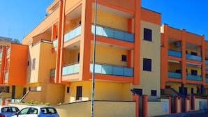 Un edificio de varios pisos con balcones y cielo despejado.