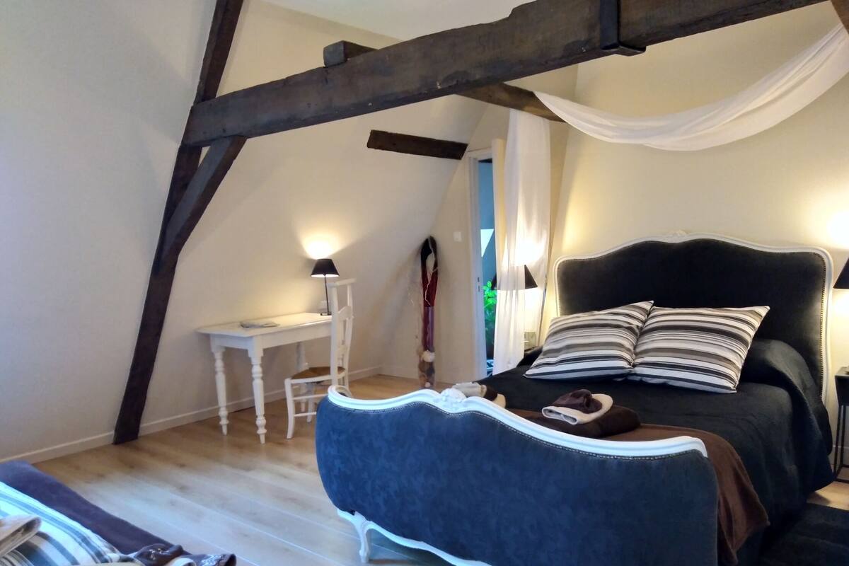 Une chambre à coucher avec un lit, une chaise, un bureau et une armoire.