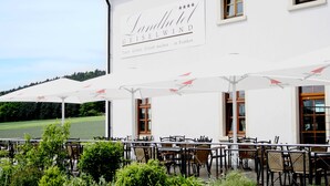 Landhotel Geiselwind con terraza y sombrillas.