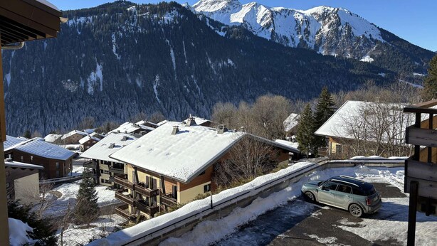 A mountain view with snow-covered buildings and a parked car. - Yéti 6 n° 8: renovated apartment at Petit Chatel (Châtel)