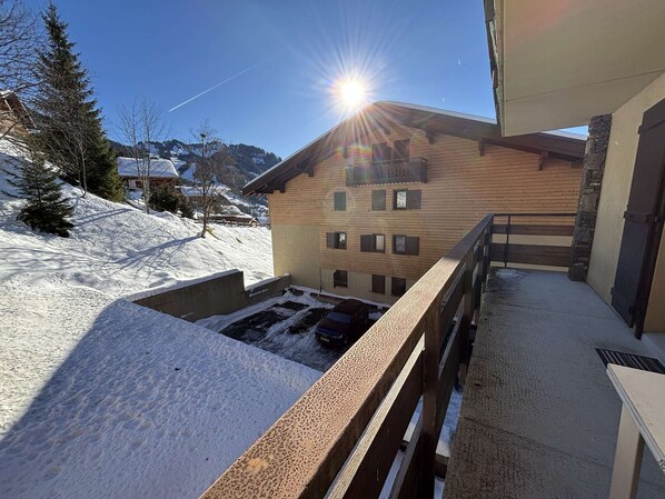 Un bâtiment en bois doté d’un balcon donnant sur un paysage enneigé.