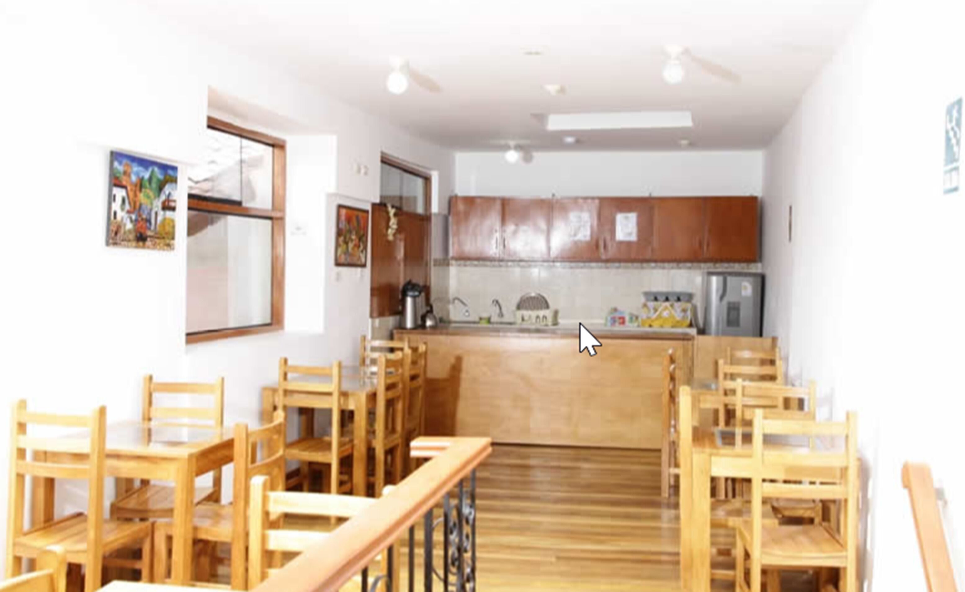 Un comedor con sillas de madera y una isla central con un lavamanos.