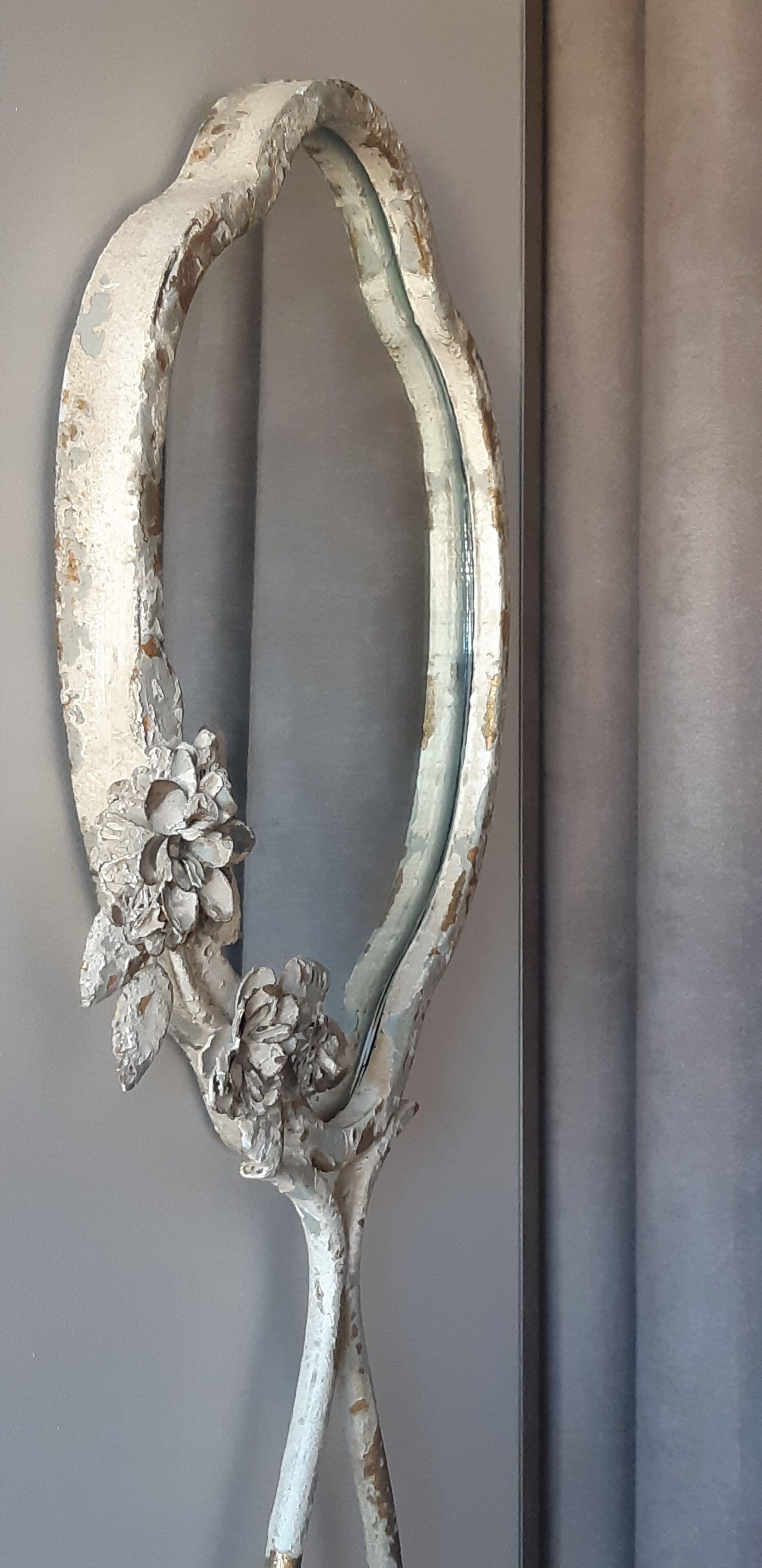 Un miroir décoratif au style rustique, avec un aspect vieilli et des motifs floraux.