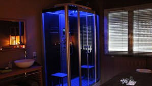 Ein modernes Badezimmer mit einer Duschkabine, einem Waschbecken und einem Spiegel.