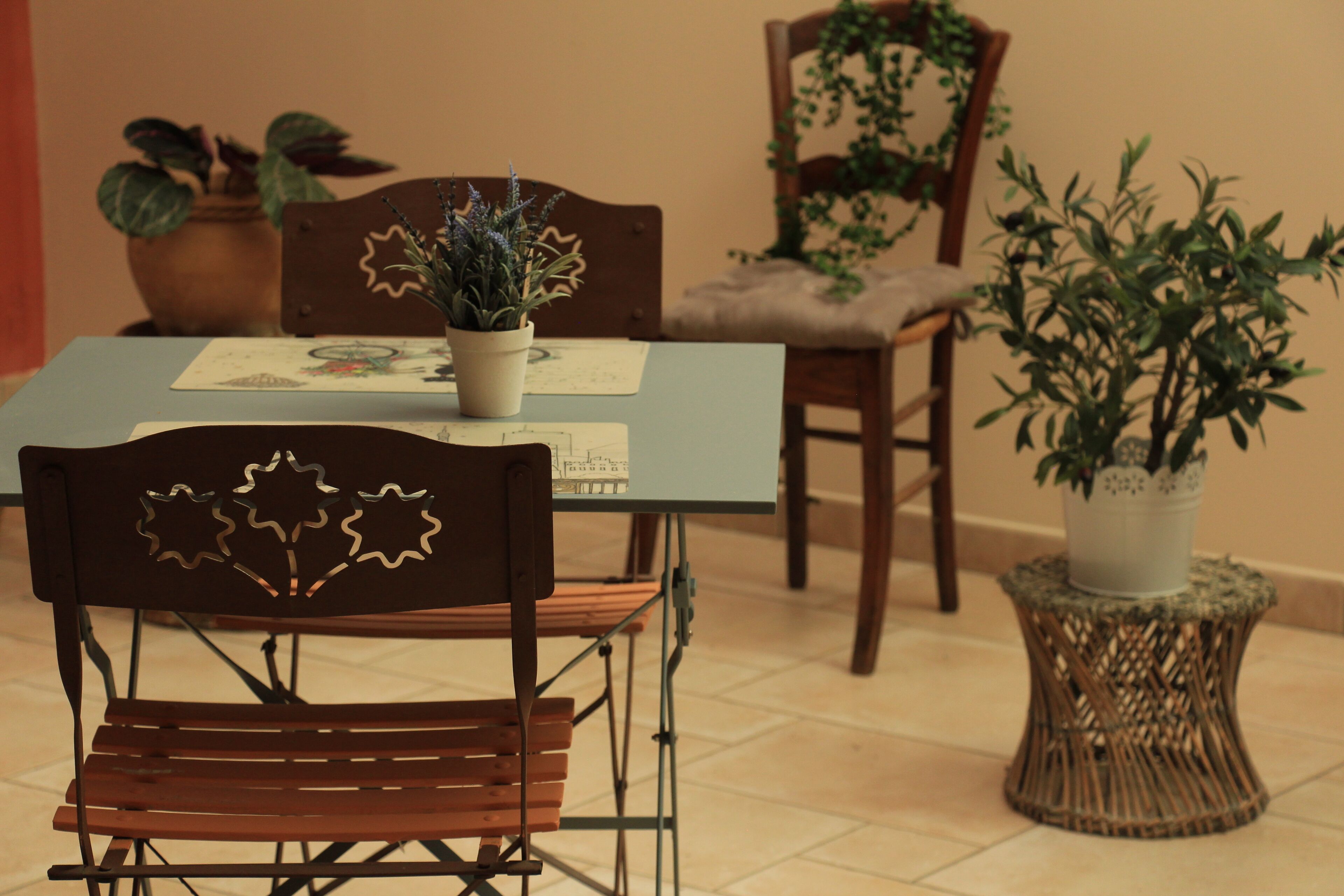 Een eethoek met een tafel voor twee personen, omringd door stoelen met decoratieve rugleuningen.