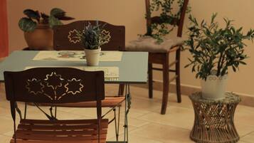 Een eethoek met een tafel voor twee personen, omringd door stoelen met decoratieve rugleuningen.