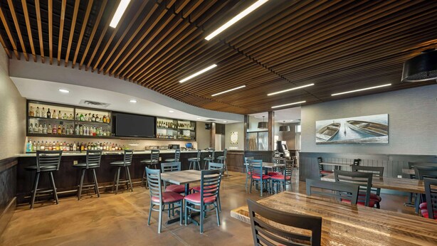 A modern bar area with a wooden ceiling, bar stools, and a variety of liquor bottles. - Best Western Plus Lakeview Hotel (Madison)