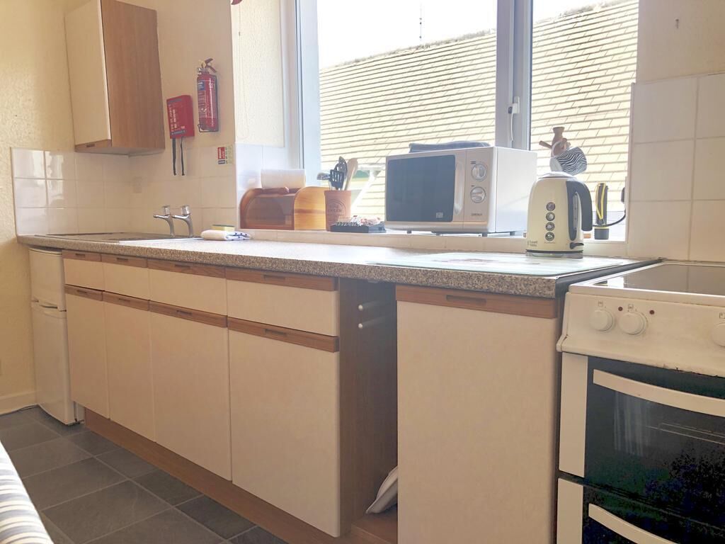 A kitchen with a microwave, toaster, and oven.