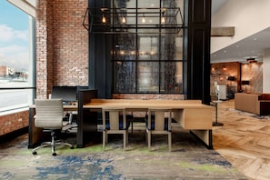 Work in style with a spacious office featuring a long table, comfortable seating area, and city views.