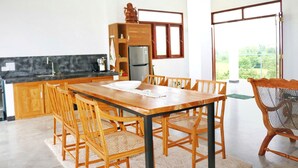 Uma cozinha moderna com armários de madeira, geladeira embutida e uma grande mesa de jantar com cadeiras.