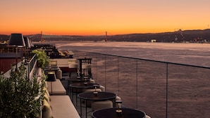 A waterfront terrace with outdoor seating and a view of a bridge. - JW Marriott Istanbul Bosphorus (Istanbul)
