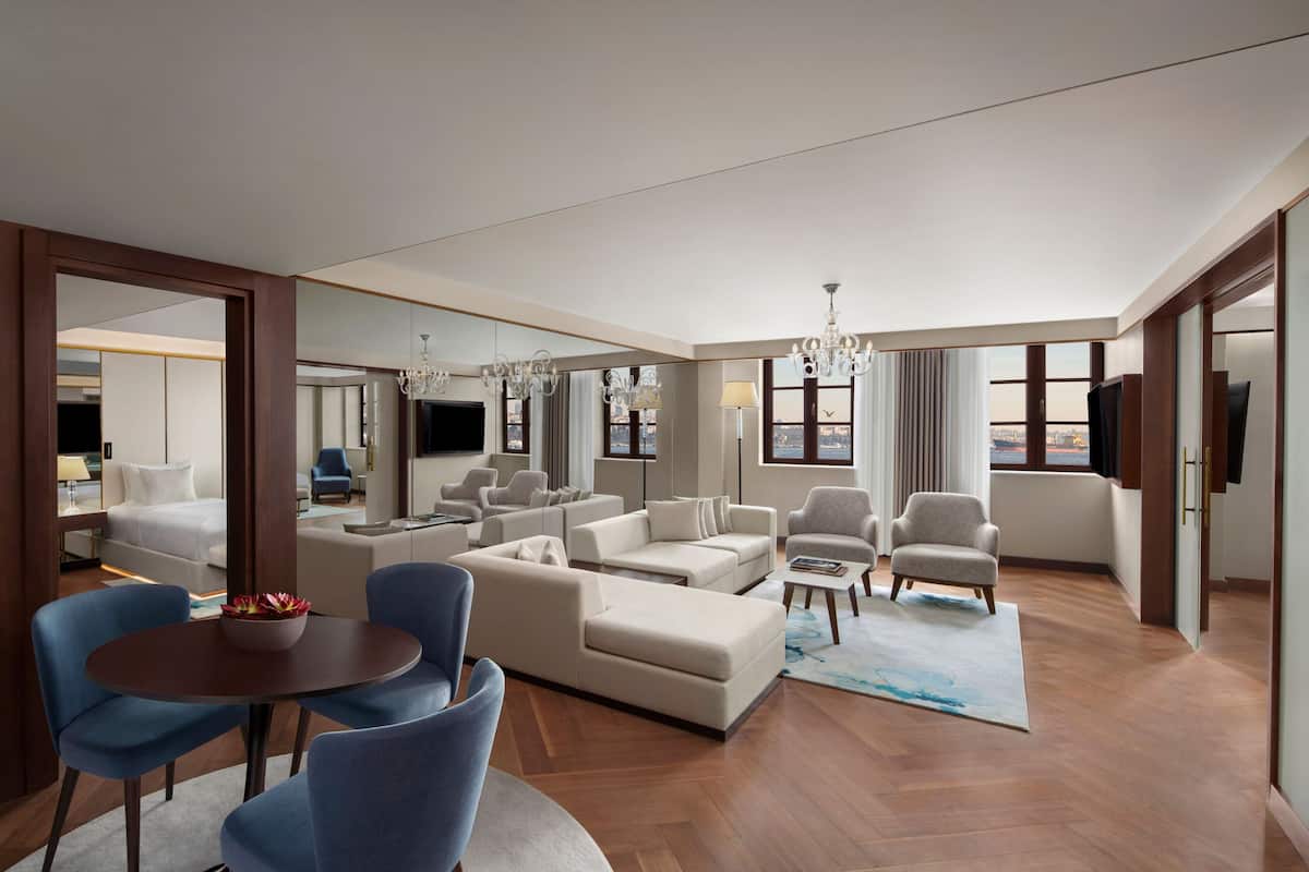 Una habitación de hotel moderna con un amplio espacio para sentarse, una mesa de comedor y un televisor.