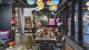 Een modern interieur met een eethoek, zitplaatsen en een keuken in de achtergrond.