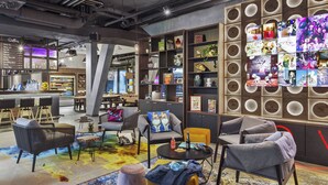 Een moderne lounge met zitplaatsen, een bar en een muur versierd met foto’s en objecten.