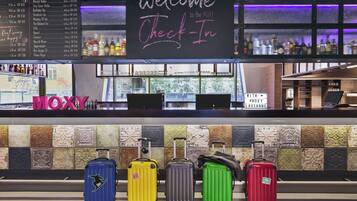 A bar area with a 'Welcome Check-In' sign, a liquor menu, and colorful tiles on the wall.