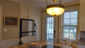 A kitchen with a stainless steel refrigerator, a glass-top stove, and a window with a view of the outdoors. - 1930'S Charming & Enchanted Unit By Waterfalls (Armdale)