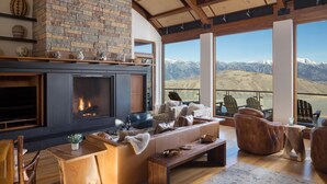 Un salon spacieux doté d’une cheminée, de sièges confortables et offrant une vue sur les montagnes.