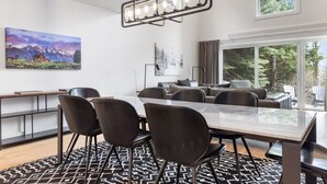 A modern dining area with a large table, black chairs, and a patterned rug. - Outpost: Four Seasons I B3 - Recently Renovated! (Teton Village)
