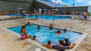 Un área de piscina con varias piscinas y sillas de descanso.