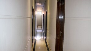 Un pasillo largo y estrecho con puertas a un lado y una fuente de luz al final.