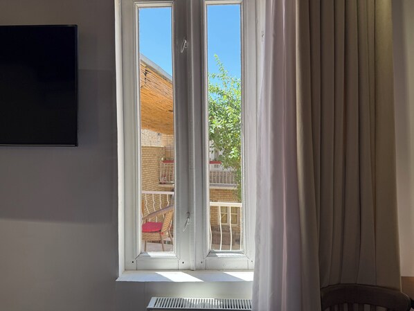 A room with a window, a radiator, and a chair.